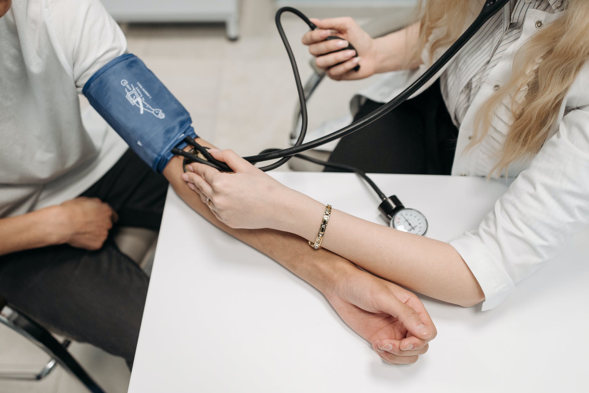 a healthcare worker measuring a patient s blood pressure using a sphygmomanometer