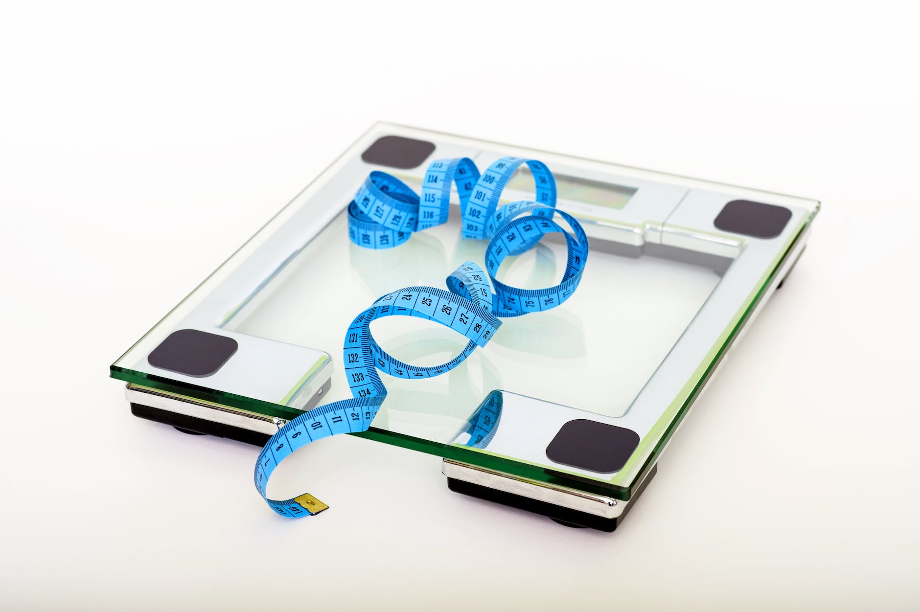 blue tape measuring on clear glass square weighing scale