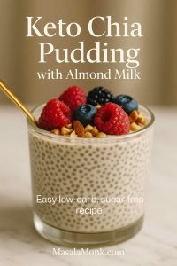 Creamy keto chia pudding with almond milk in a glass jar, topped with berries and nuts, gold spoon on marble—MasalaMonk.com footer