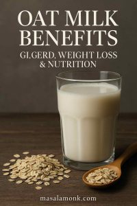 A tall glass of oat milk with oats and a wooden spoon on a dark background, illustrating the blog post on oat milk benefits for GI, GERD, weight loss, and nutrition.