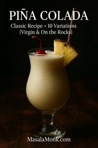Moody piña colada in a hurricane glass with pineapple and cherry—classic recipe and variations by MasalaMonk.