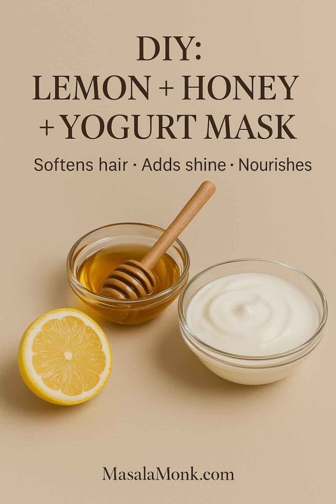 Flat-lay of a halved lemon, a glass bowl of golden honey with a wooden dipper, and a bowl of creamy yogurt on a beige background. Magazine-style DIY image with overlay text: DIY Lemon + Honey + Yogurt Mask — Softens hair, adds shine, nourishes — MasalaMonk.com.