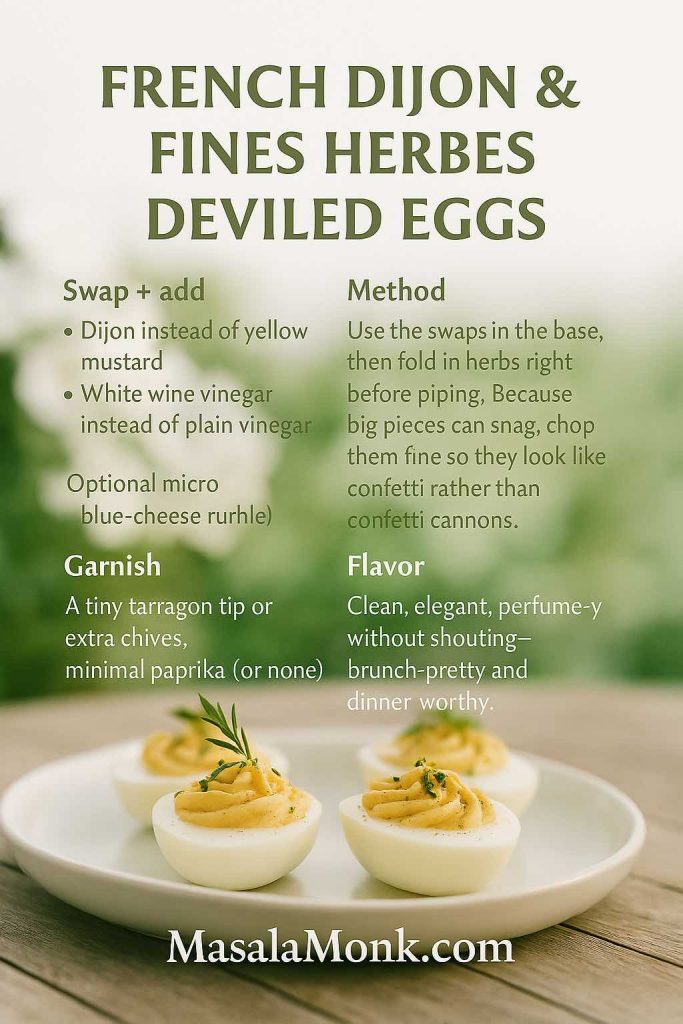 French Dijon & fines herbes deviled eggs on pale stoneware at an outdoor table with soft garden bokeh; portrait recipe card overlay with swaps, method, garnish, and flavor; MasalaMonk.com footer.