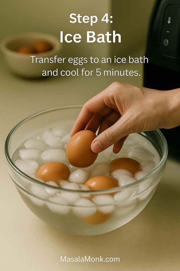 Step 4 for air fryer hard boiled eggs – hand lowering a cooked egg into a glass bowl filled with ice water to cool the eggs quickly.