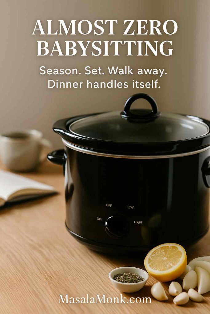 Black crock pot set to low on a wooden counter with lemon, garlic and herbs, illustrating the hands-off prep for a whole chicken in a slow cooker.