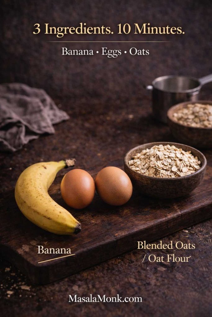Banana, two eggs, and a bowl of oats on a dark tabletop with text “3 Ingredients. 10 Minutes.” for 3 ingredient oatmeal pancakes.