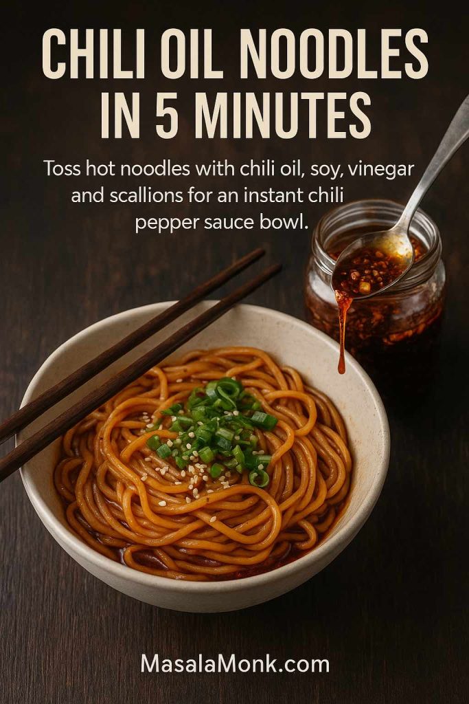Bowl of noodles coated in glossy red chili oil, topped with scallions and sesame seeds, with a jar of Sichuan chili oil and spoon beside it on a dark wooden table and text describing a quick chili oil noodle recipe.