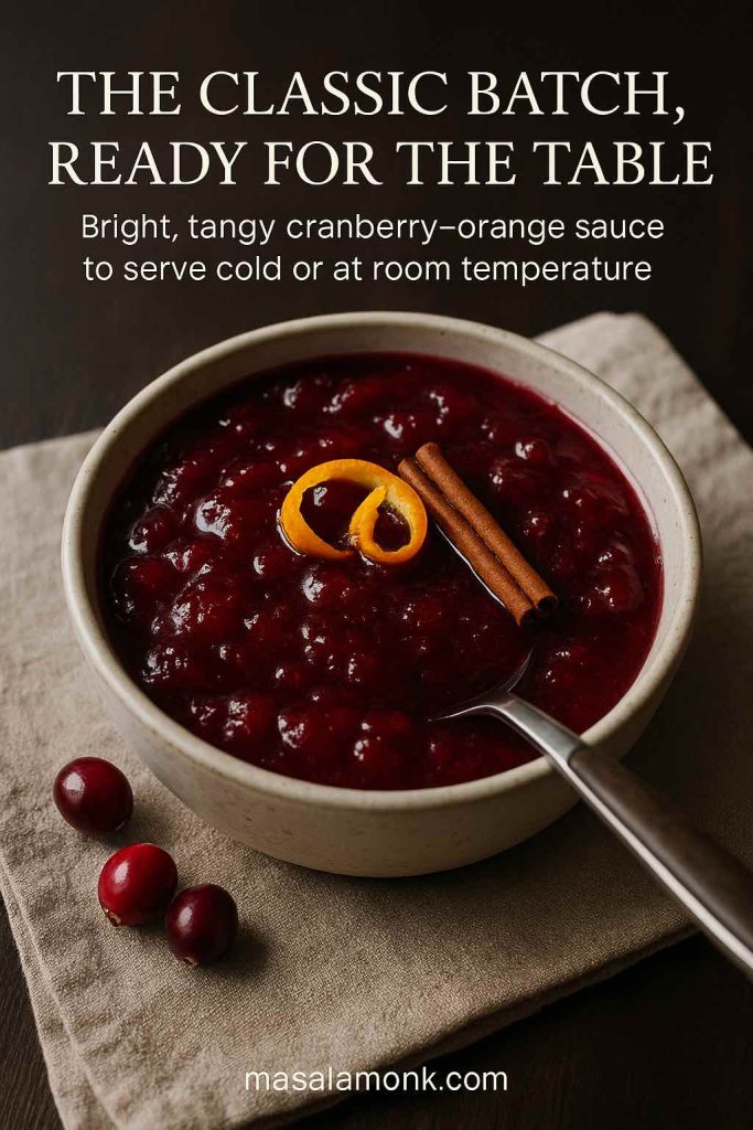 Classic homemade cranberry orange sauce in a ceramic bowl, garnished with a curl of orange zest and a cinnamon stick, ready to serve as a side dish.