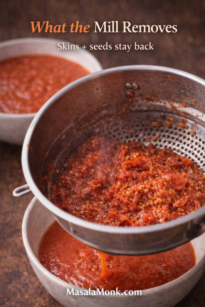 Tomato skins and seeds left behind in a food mill after processing cooked tomatoes into smooth tomato sauce.