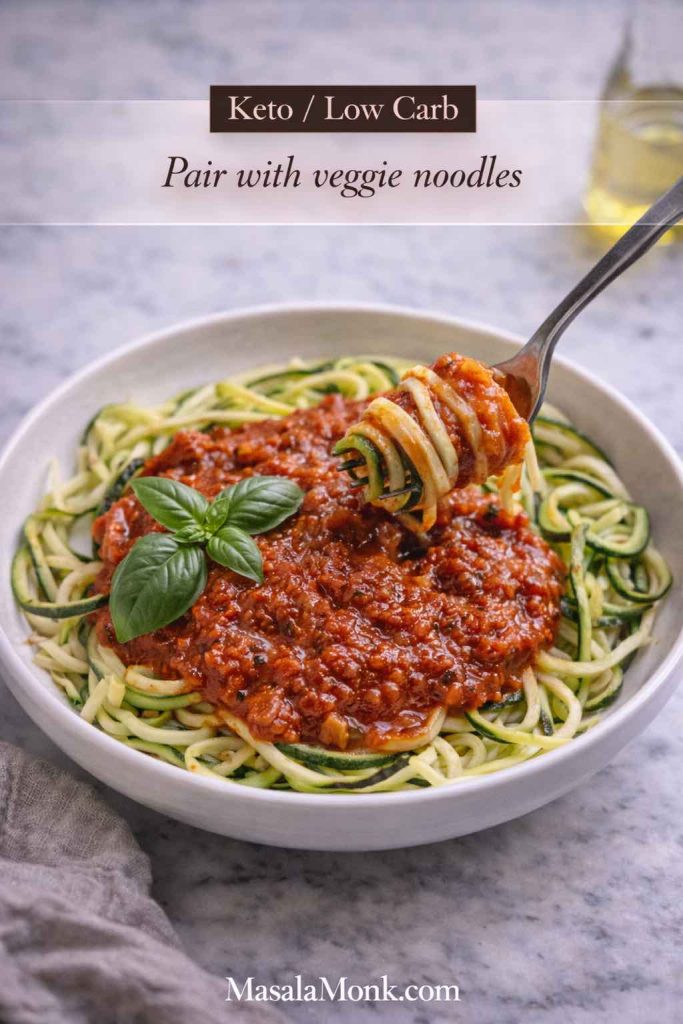 Zucchini noodles topped with marinara sauce and basil in a bowl, showing a keto and low carb way to serve tomato sauce.