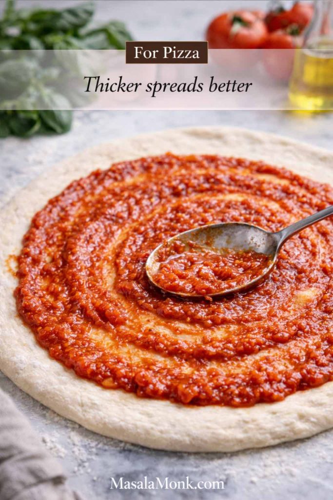 Thick marinara sauce being spread with a spoon on pizza dough, showing how to use marinara sauce for pizza without making the crust soggy.
