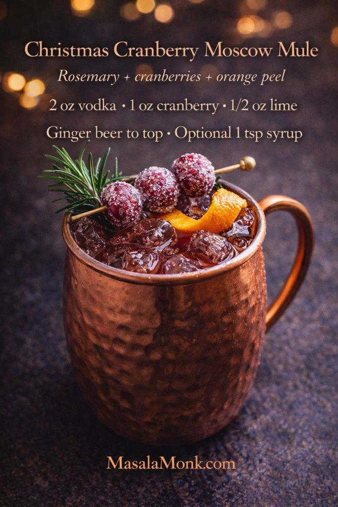 Christmas cranberry Moscow mule in a copper mug with sugared cranberries, rosemary, and orange peel, featuring an on-image recipe with vodka, cranberry, lime, and ginger beer.