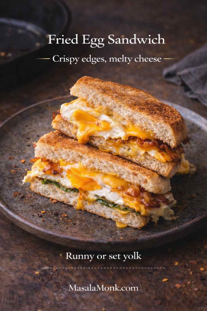 Fried egg sandwich recipe card showing a toasted sandwich cut in half with crispy-edged fried egg, melted cheese, and optional runny or set yolk, with MasalaMonk.com branding.