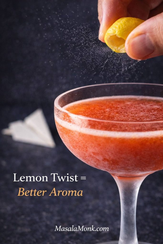 Close-up of a Paper Plane cocktail in a coupe as a lemon twist is expressed over the drink, releasing citrus oils, with text “Lemon Twist = Better Aroma.”