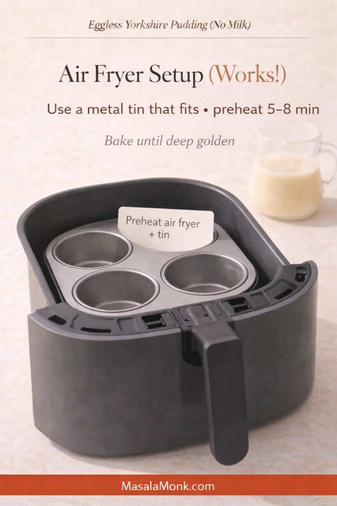 Air fryer setup for eggless Yorkshire pudding (no milk) showing a small metal muffin tin inside an air fryer basket with text overlay: “Use a metal tin that fits • preheat 5–8 min • bake until deep golden,” and MasalaMonk.com in the footer.