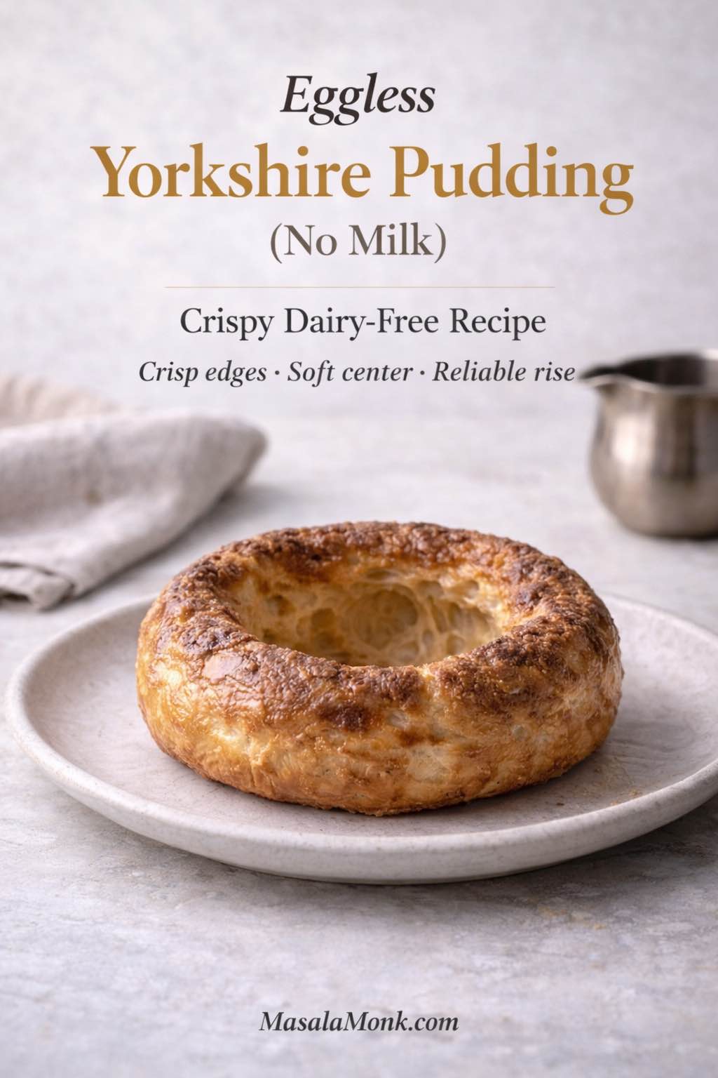 Eggless Yorkshire pudding made without milk on a plate, showing a golden, crisp rim and hollow center—dairy-free Yorkshire pudding recipe cover image.