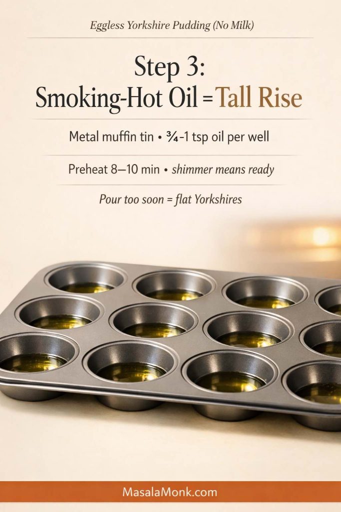 Metal muffin tin filled with small pools of shimmering hot oil, shown as Step 3 for eggless Yorkshire pudding (no milk) with text overlay about preheating 8–10 minutes and a footer that reads MasalaMonk.com.