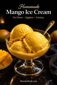 Homemade mango ice cream in a glass dessert coupe with smooth creamy scoops, deep mango color, and a dark luxe background, styled as a no-churn eggless mango ice cream hero image.