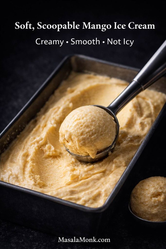 Soft scoopable homemade mango ice cream in a loaf pan with visible scoop marks, showing a creamy smooth texture after freezing.