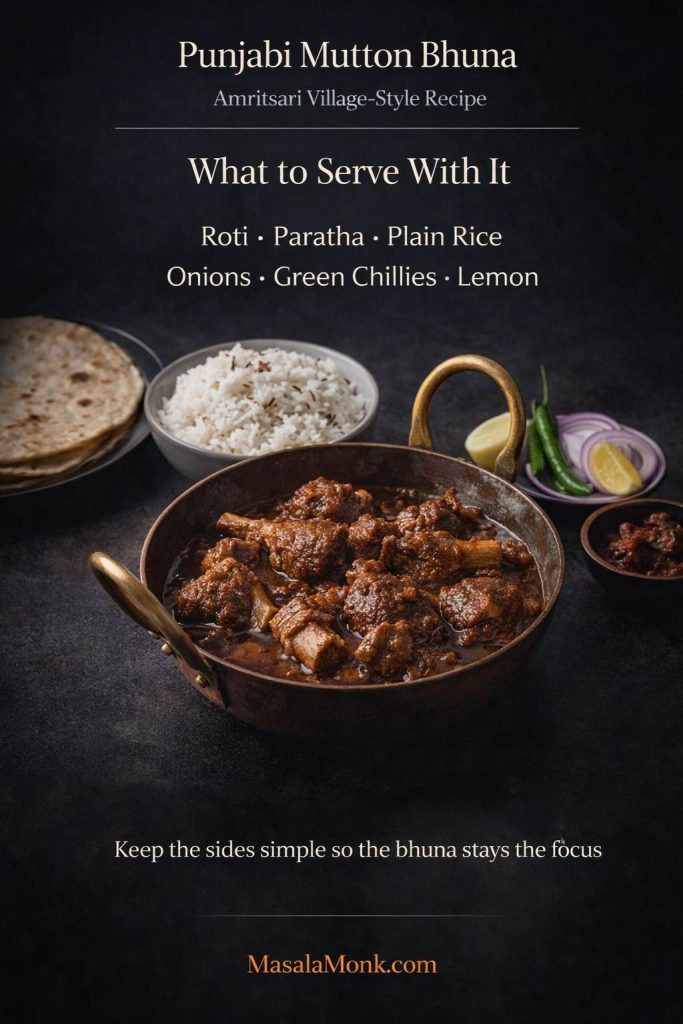 Serving suggestions for Punjabi mutton bhuna showing the dish with roti, plain rice, sliced onions, green chillies, lemon, and pickle.
