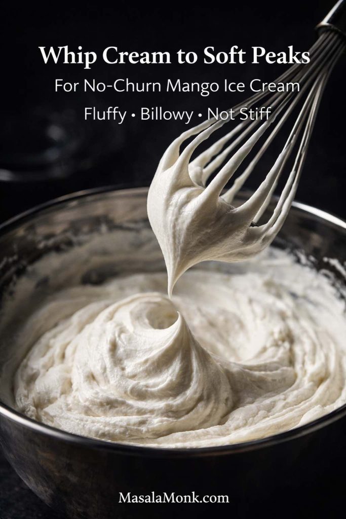 Whipped cream at soft peak stage in a mixing bowl, showing the right texture for no-churn homemade mango ice cream.