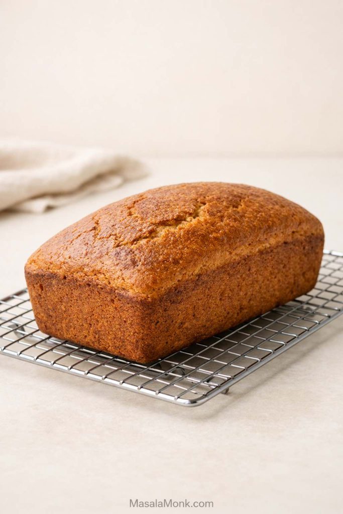 Gluten free sourdough loaf cooling on a wire rack after baking.