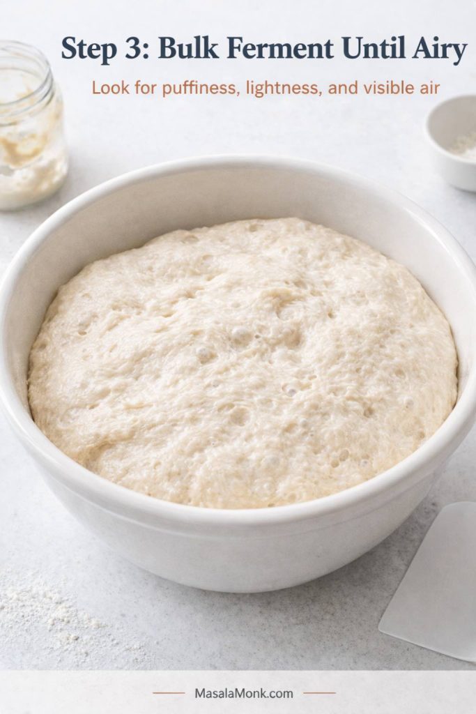 Step 3 process image for sourdough English muffins showing bulk-fermented dough in a bowl, puffier and more aerated than before, with a soft surface and visible air bubbles that signal the dough is ready for the next stage.