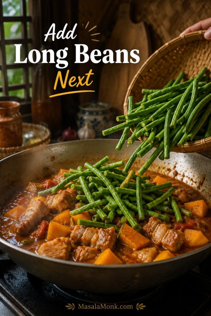 Long beans being added to partially cooked squash and pork in a wide pan of Pinakbet Tagalog.