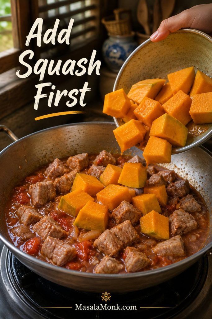 Orange squash chunks being added to pork and tomato-bagoong sauce in a wide pan for pinakbet.