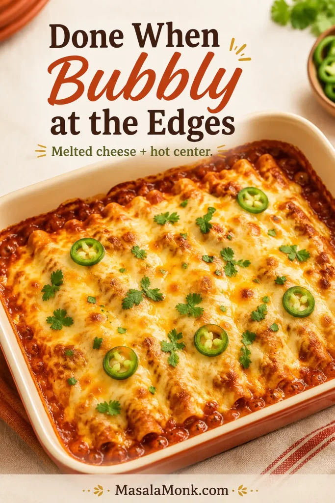 Baked chicken enchilada casserole with bubbling red sauce around the edges and melted cheese on top.