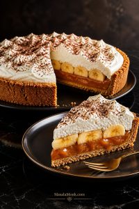Whole Banoffee Pie with a clean slice showing biscuit base, caramel, bananas, whipped cream, and chocolate shavings.