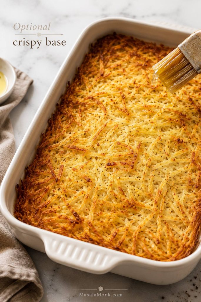 Pre-baked crispy hash brown base in a baking dish before eggs, sausage, and cheese are added.