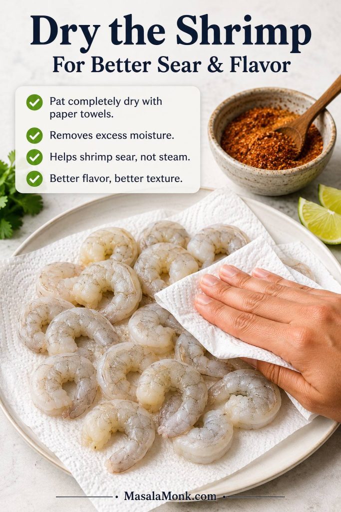Raw peeled shrimp being patted dry on paper towels before seasoning for shrimp tacos