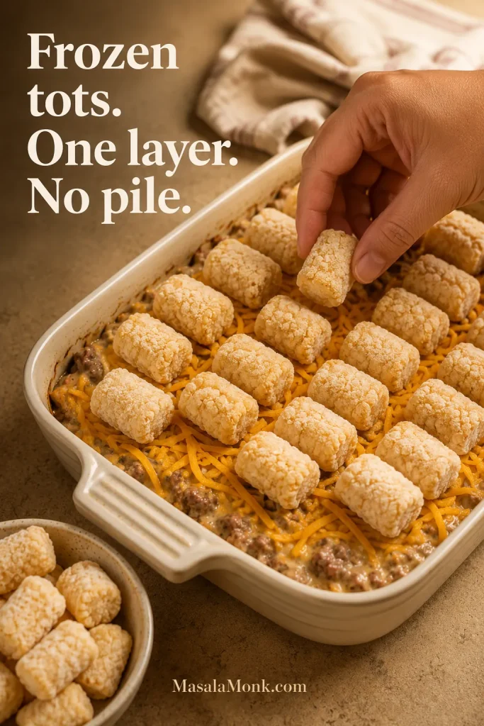 Frozen tater tots arranged in one layer over tater tot casserole filling with extra tots kept aside