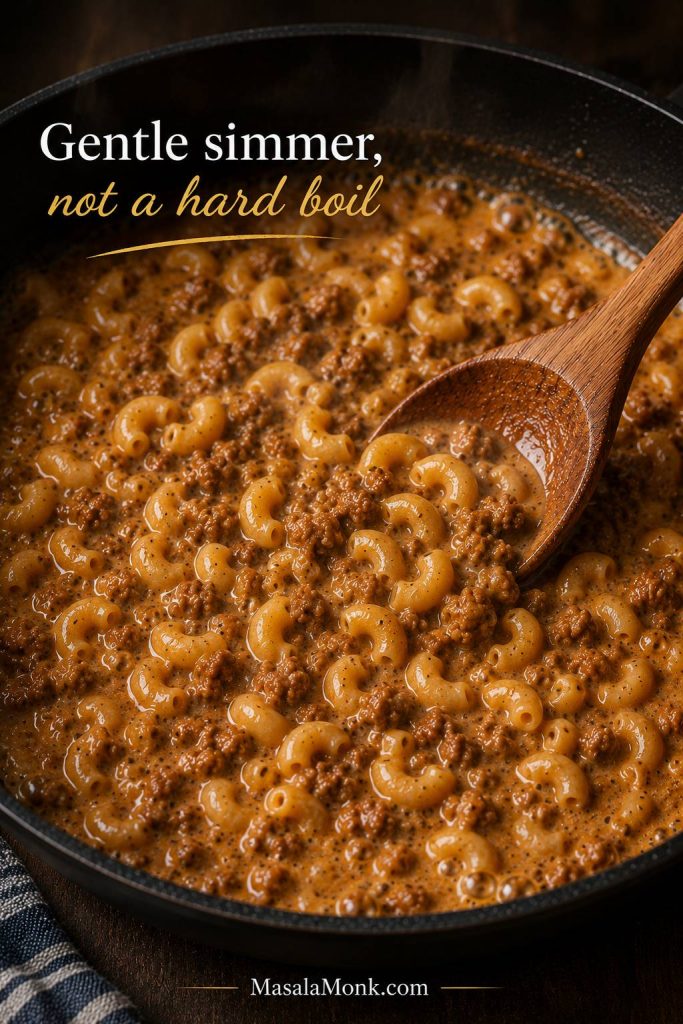 Homemade Hamburger Helper simmering gently in a skillet with macaroni, ground beef, milk, and broth.