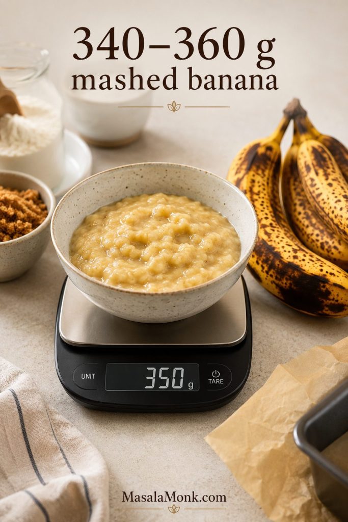 Bowl of mashed banana on a digital scale reading 350 grams with ripe bananas nearby and the text “340–360 g mashed banana.”