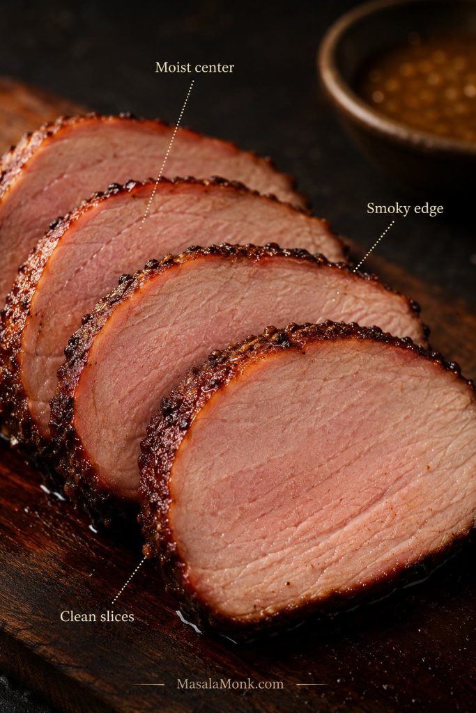 Close-up of smoked pork loin slices with moist center, smoky edge, and clean slice texture