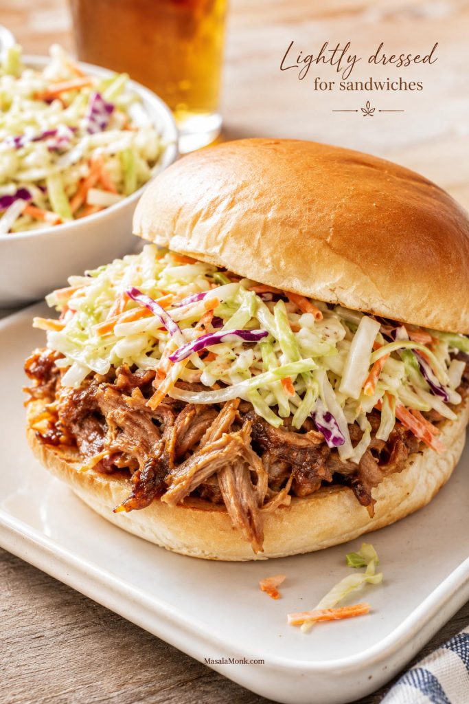 Pulled pork sandwich topped with lightly dressed coleslaw on a soft bun.