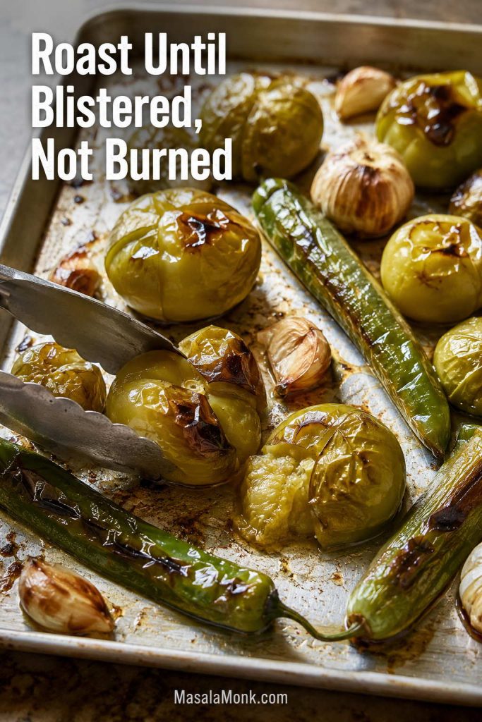 Tomatillos, green chiles, and unpeeled garlic blistered on a sheet pan for roasted salsa verde