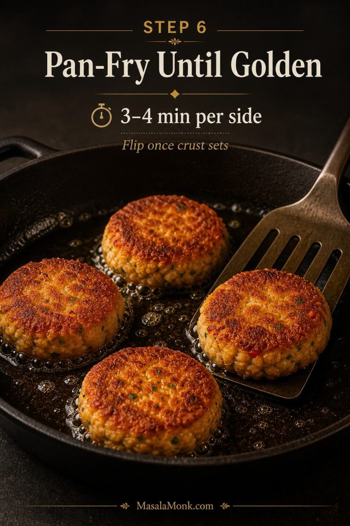 Salmon croquettes frying in shallow oil in a skillet until golden brown