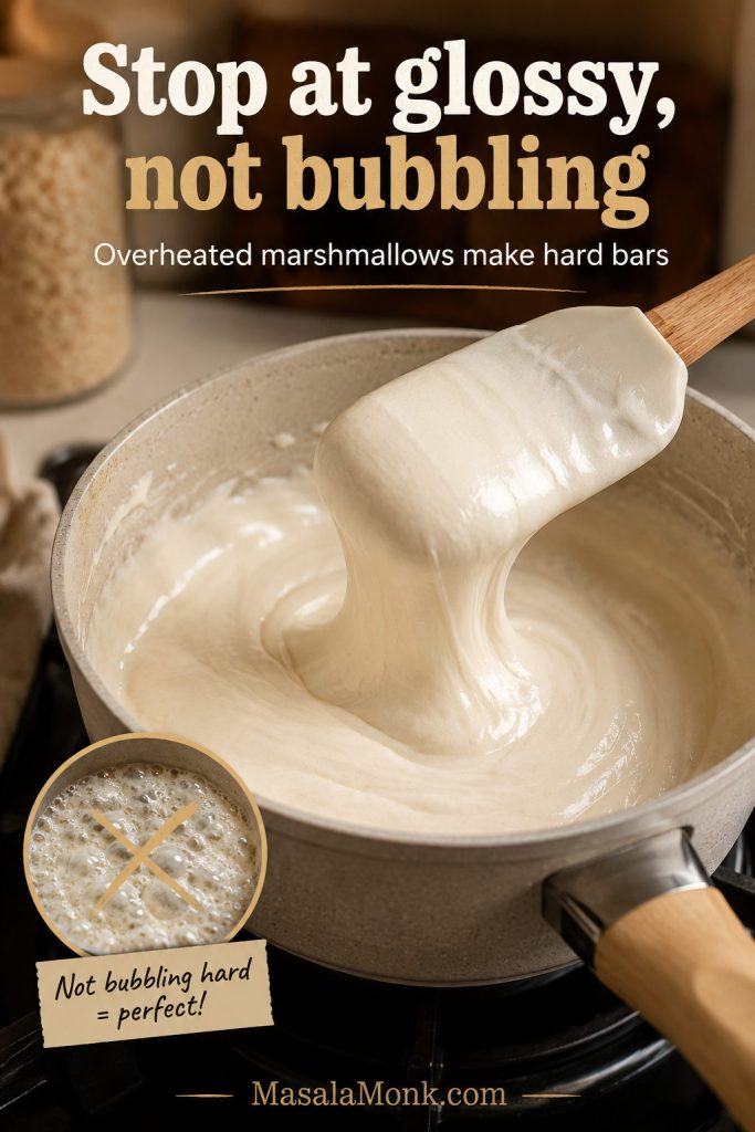 Glossy melted marshmallows in a saucepan being lifted with a spatula before the mixture bubbles hard.