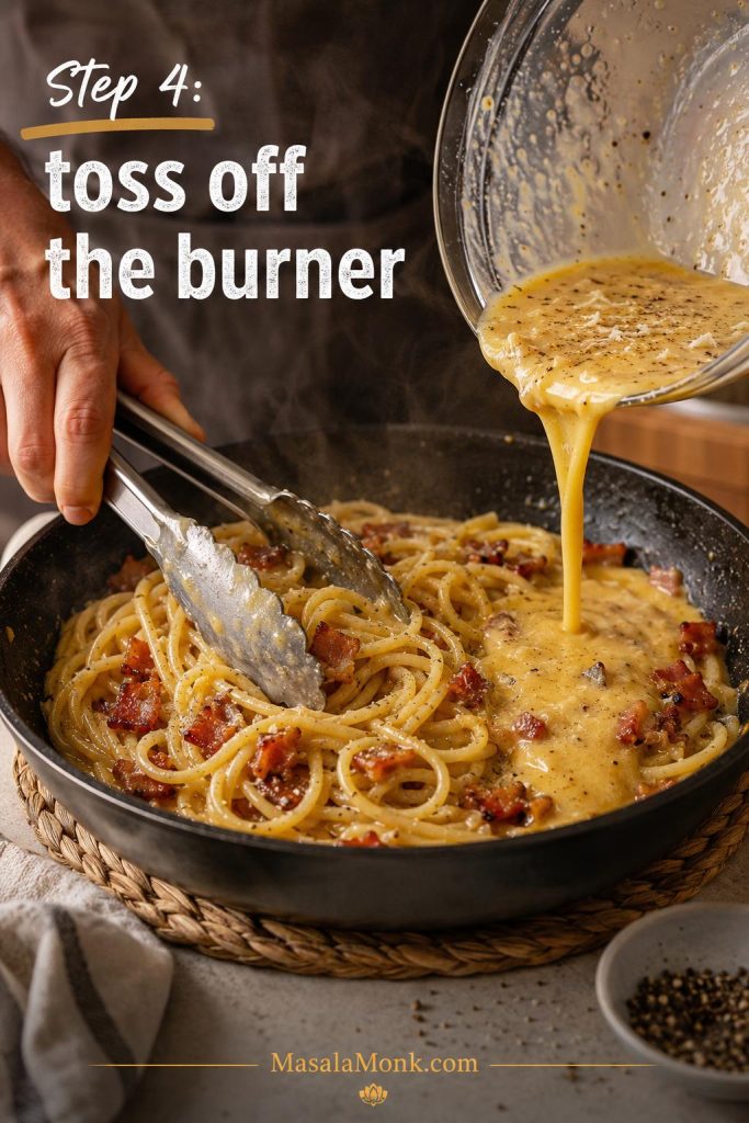 Egg and cheese mixture being poured over hot spaghetti and bacon while tongs toss the pasta.