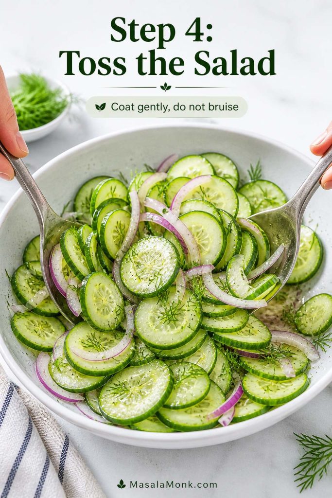 Cucumber slices, red onion, dill, and vinegar dressing being gently tossed in a bowl.