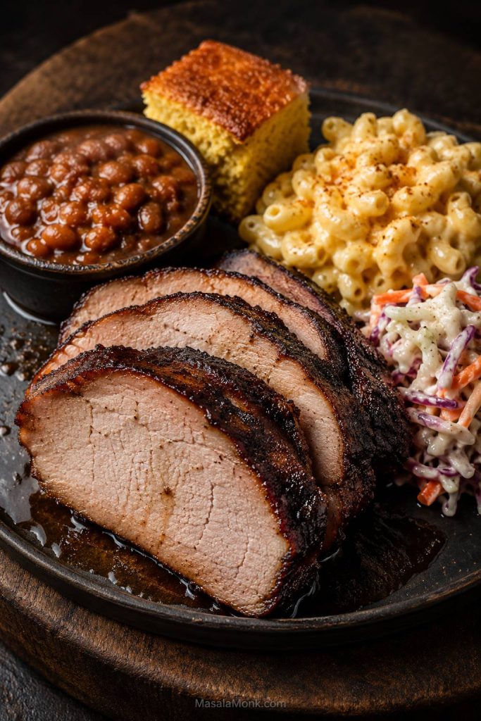 Smoked pork loin served with macaroni and cheese, slaw, baked beans, and cornbread