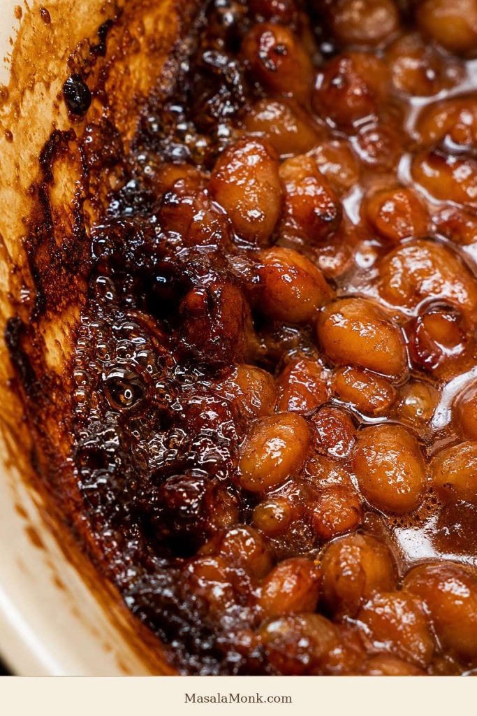 Close-up of baked beans bubbling along the edge of a dish.