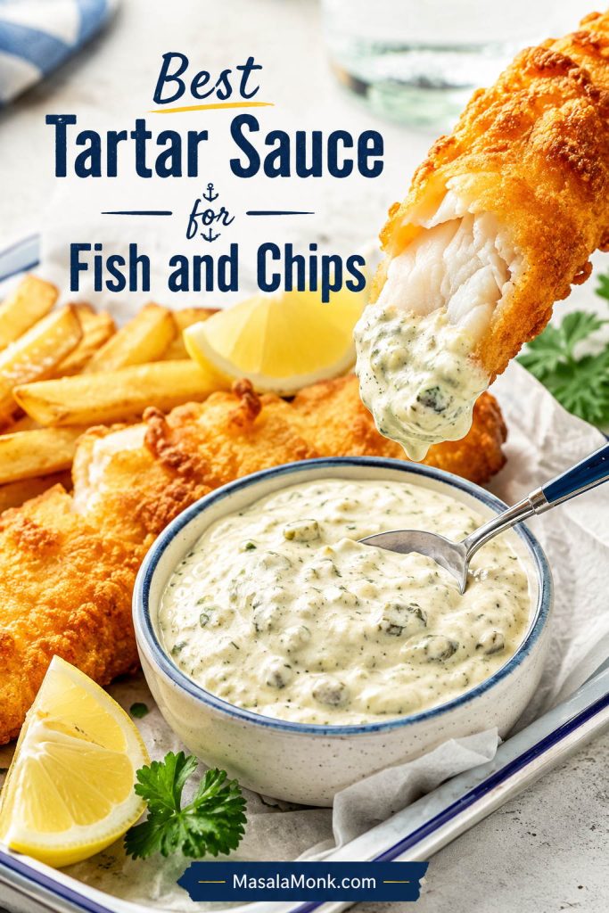 Crispy battered fish being dipped into thick homemade tartar sauce with chips and lemon nearby