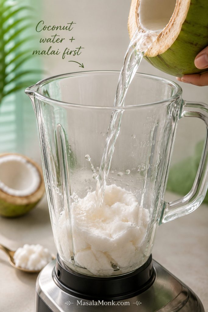 Coconut water being poured into a blender jar filled with tender coconut malai.