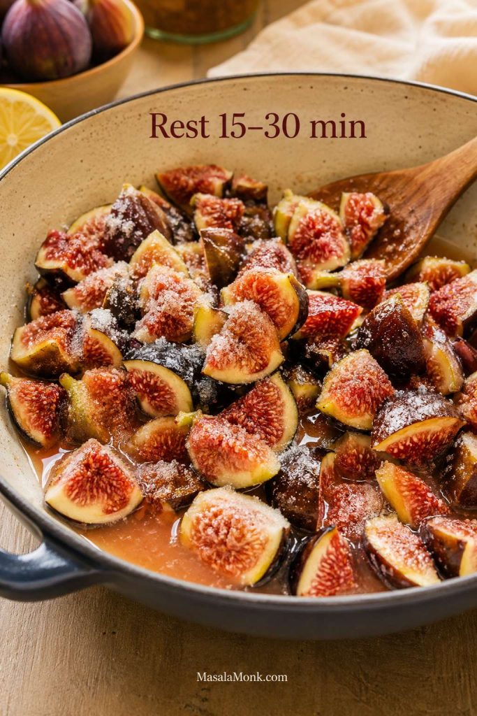 Chopped figs resting with sugar and lemon juice as syrup begins forming in the bowl.
