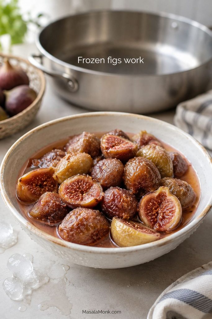 Thawed frozen figs in a bowl with released juices and a jam pan in the background.