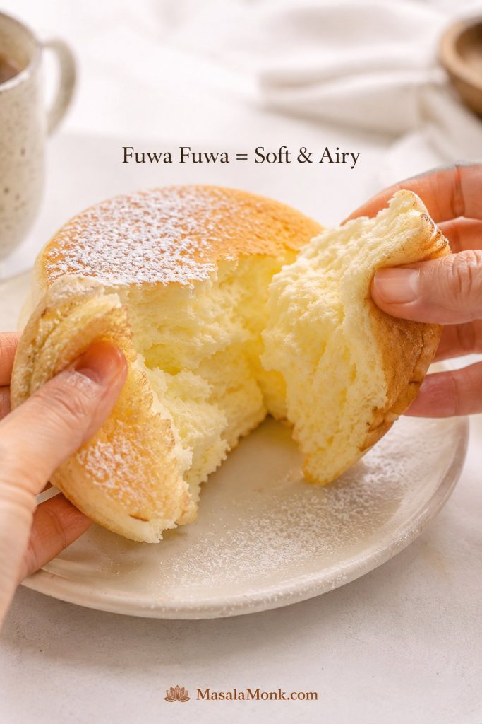 A Japanese pancake being pulled open to show a soft airy interior crumb.